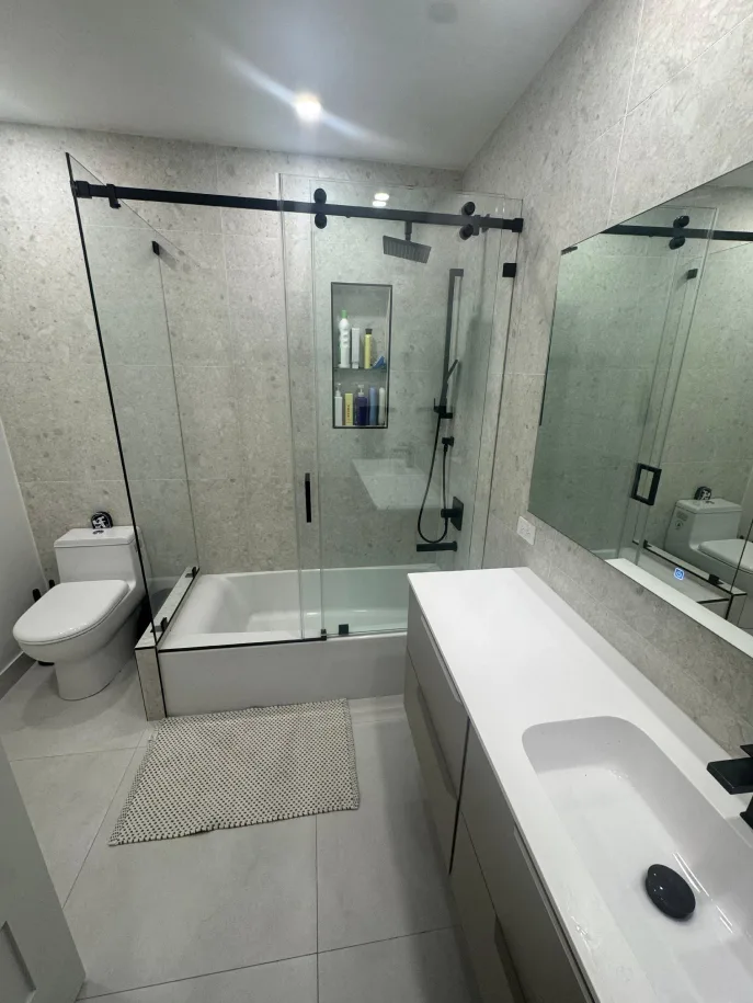 Full bathroom with tub-shower combo, toilet, floating vanity, and large mirror