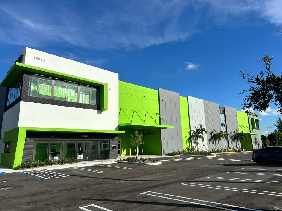 Two-story storage facility facade with Now Open signage and fresh parking lot