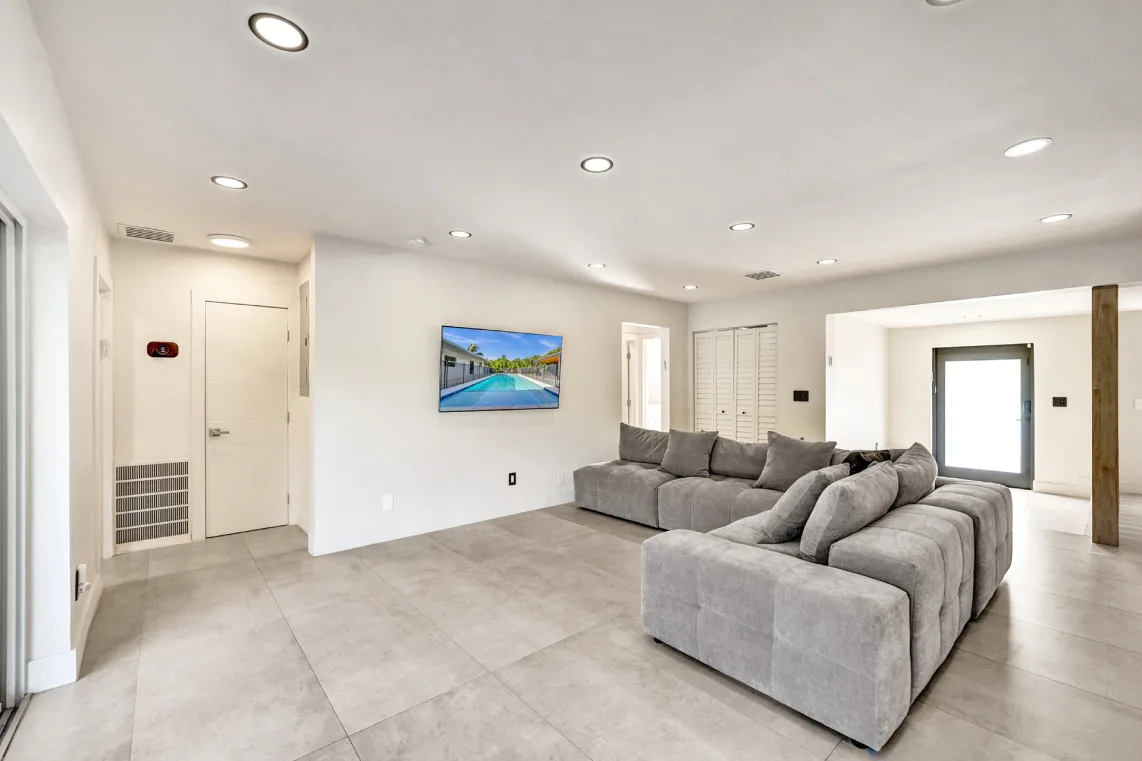 Great room with gray sectional and wall TV in an open floor plan