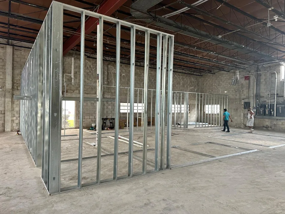 Warehouse interior under construction with metal stud partition framing and layout tracks